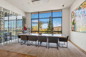 Dining room with wood finished floors, healthy amount of natural light, and expansive windows