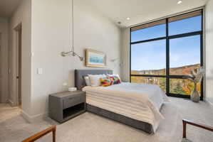 Bedroom with expansive windows, light colored carpet, recessed lighting, and a mountain view
