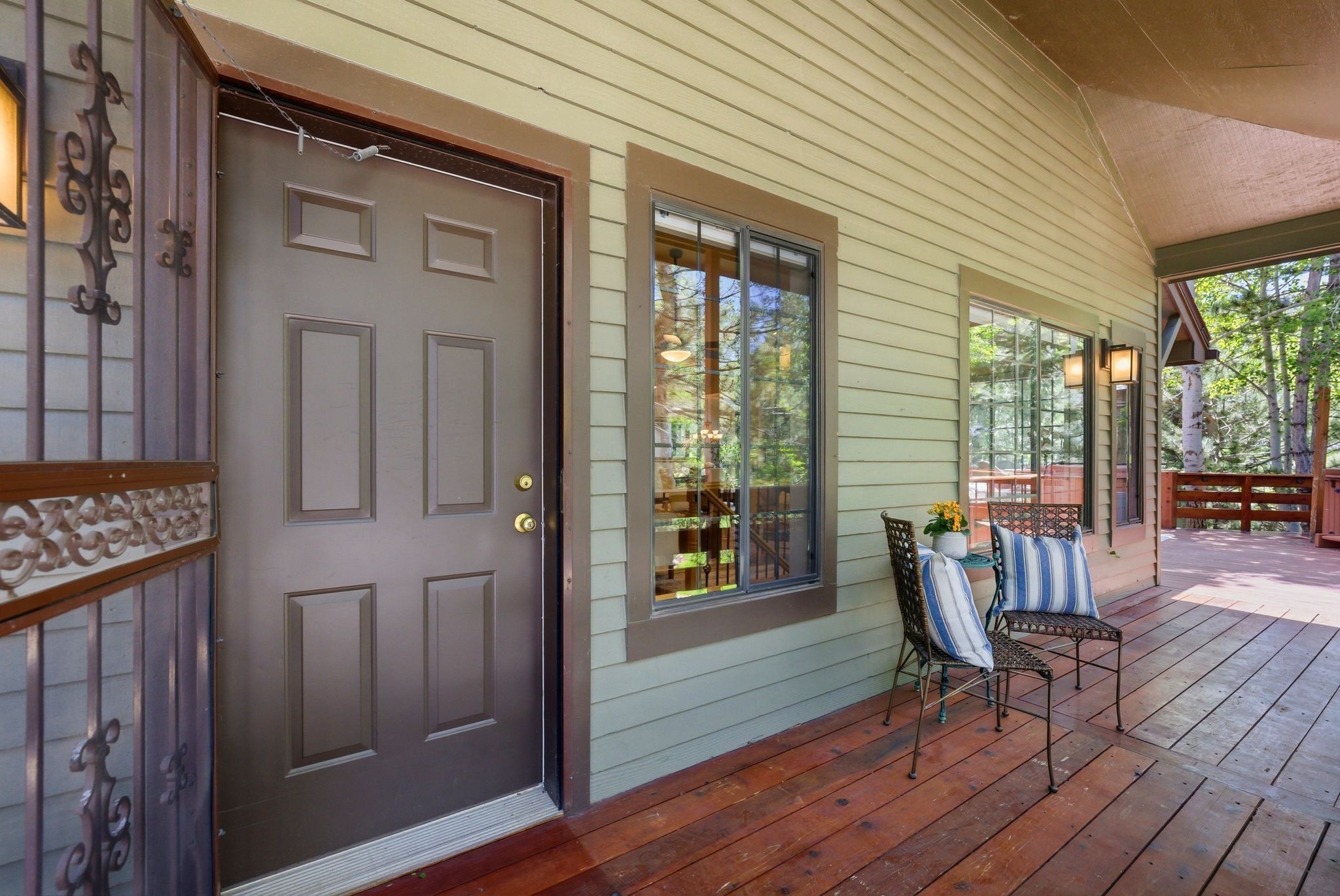 Expansive covered porch featuring wood-finish flooring and a light green horizontal siding exterior