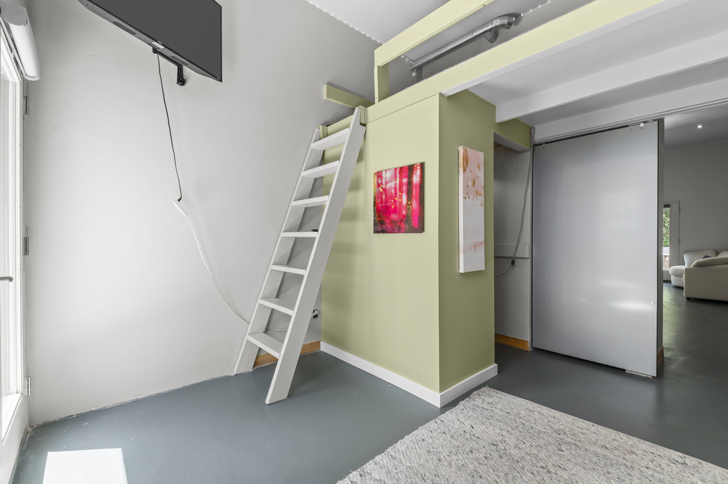 Mezzanine access ladder with neutral wall tones and dark grey flooring