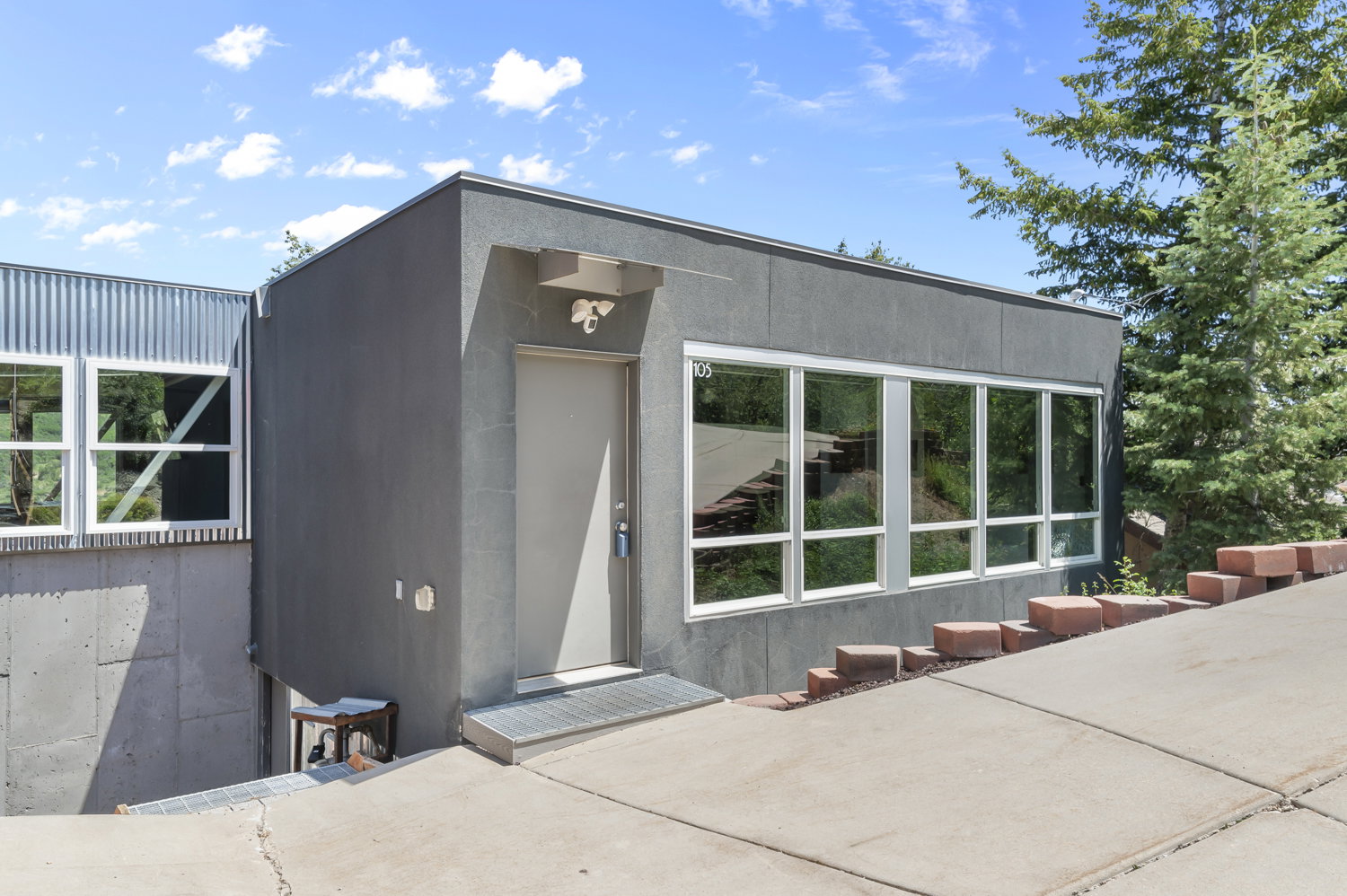 Modern architectural exterior featuring a flat roofline and a corrugated metal accent wall