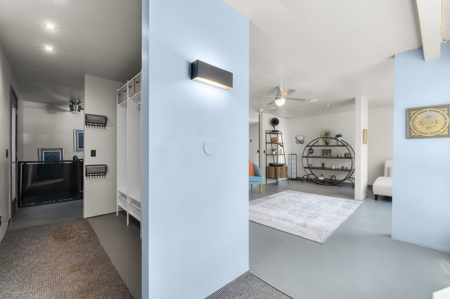Open floor plan featuring light blue accent walls and recessed lighting