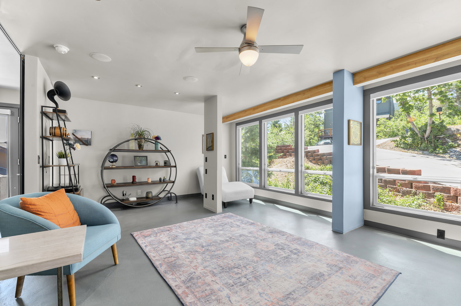 Open living area featuring multiple large windows, recessed lighting, a ceiling fan, and light-colored flooring