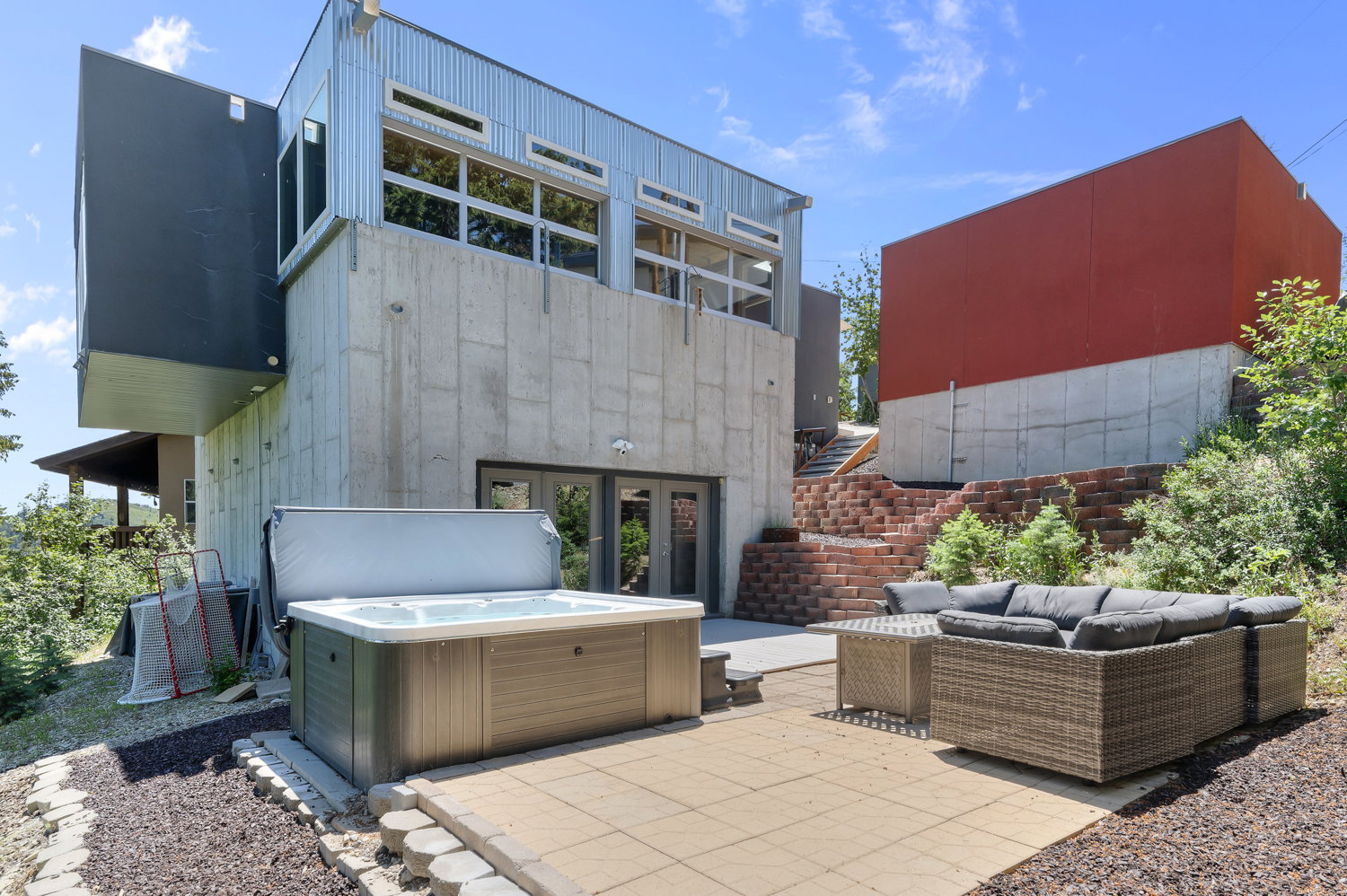 Outdoor patio featuring a built-in hot tub and stone paver flooring