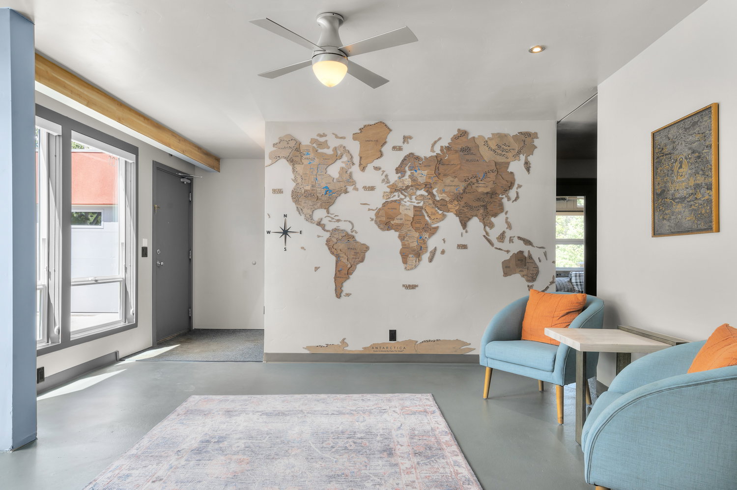 Open-concept space featuring light gray flooring, white walls, and a contemporary ceiling fan with integrated lighting