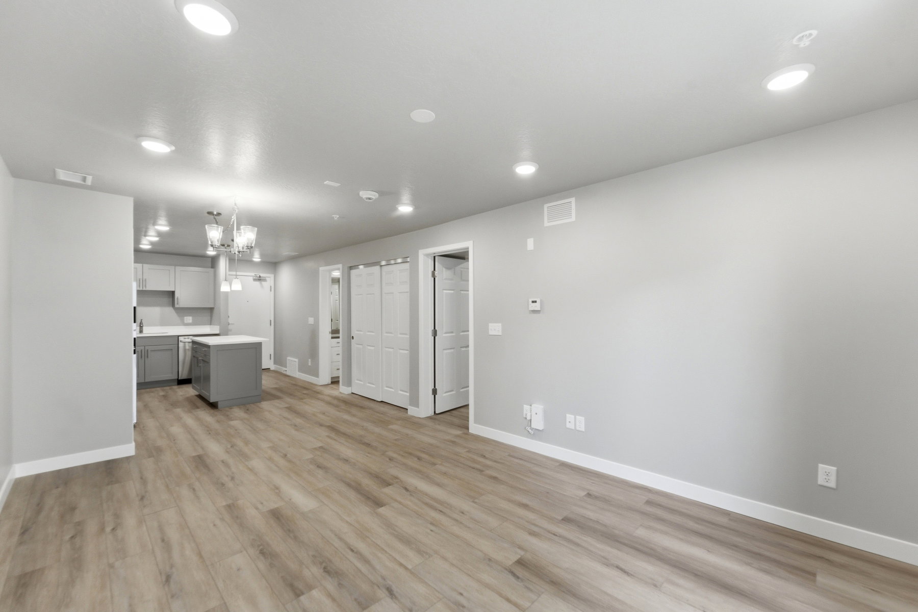 Open concept living space featuring wood-finish flooring, recessed lighting, and a modern kitchen