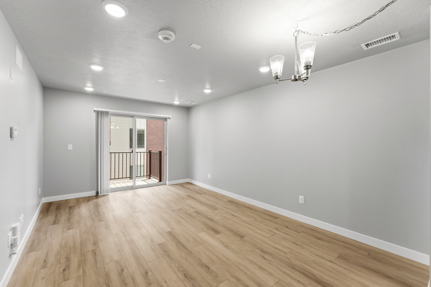 Open-concept room featuring wood-finish flooring, recessed lighting, and a modern chandelier