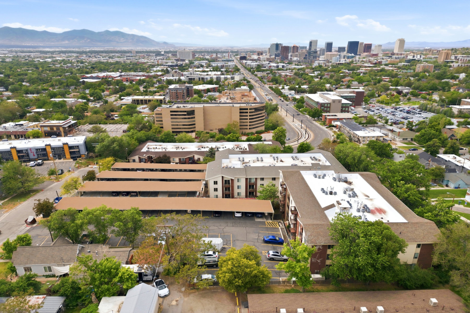Aerial perspective showcasing multi-story apartment buildings with covered parking structures