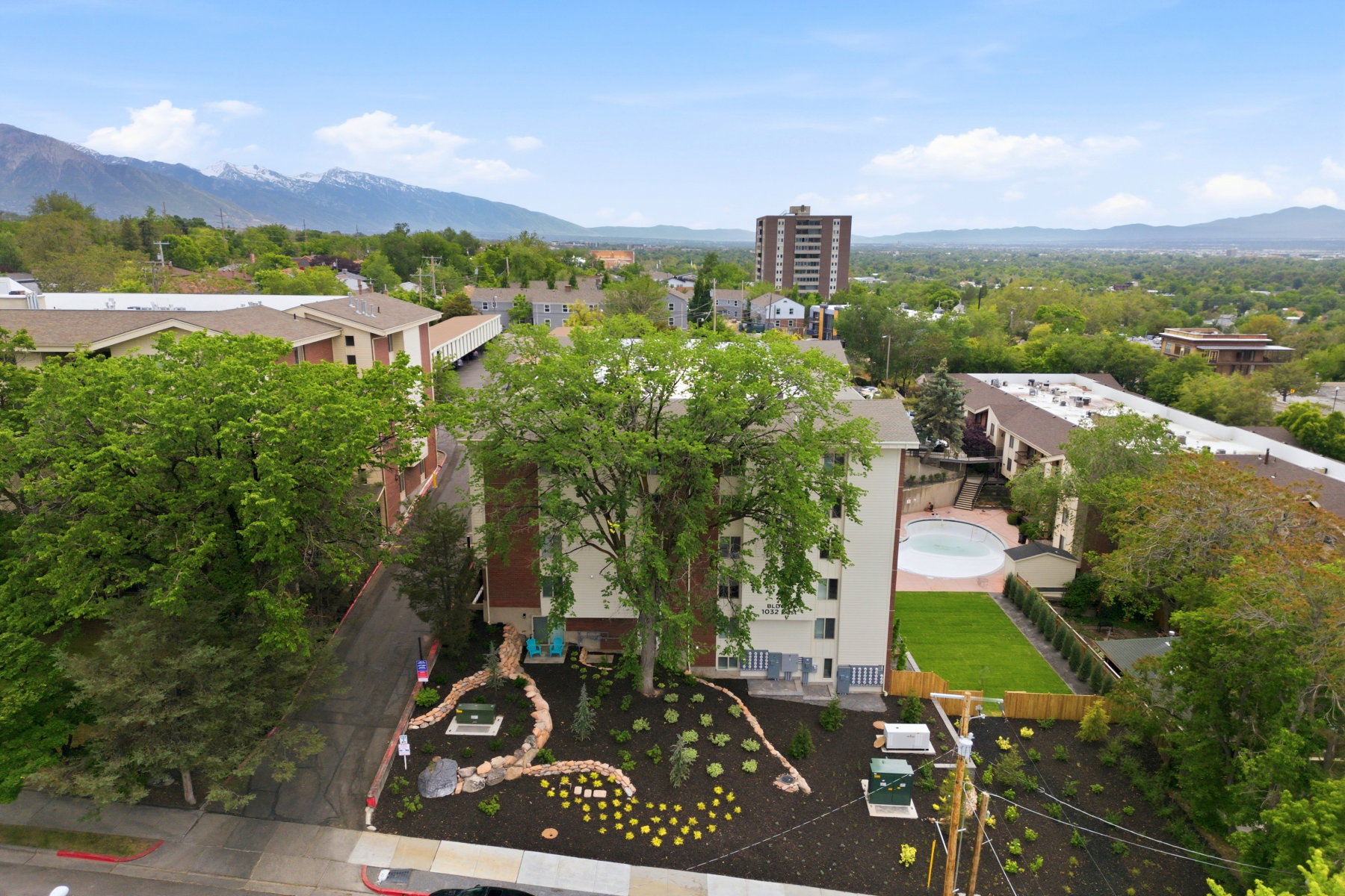 Multi-story building featuring a landscaped front area with decorative rockwork and plantings