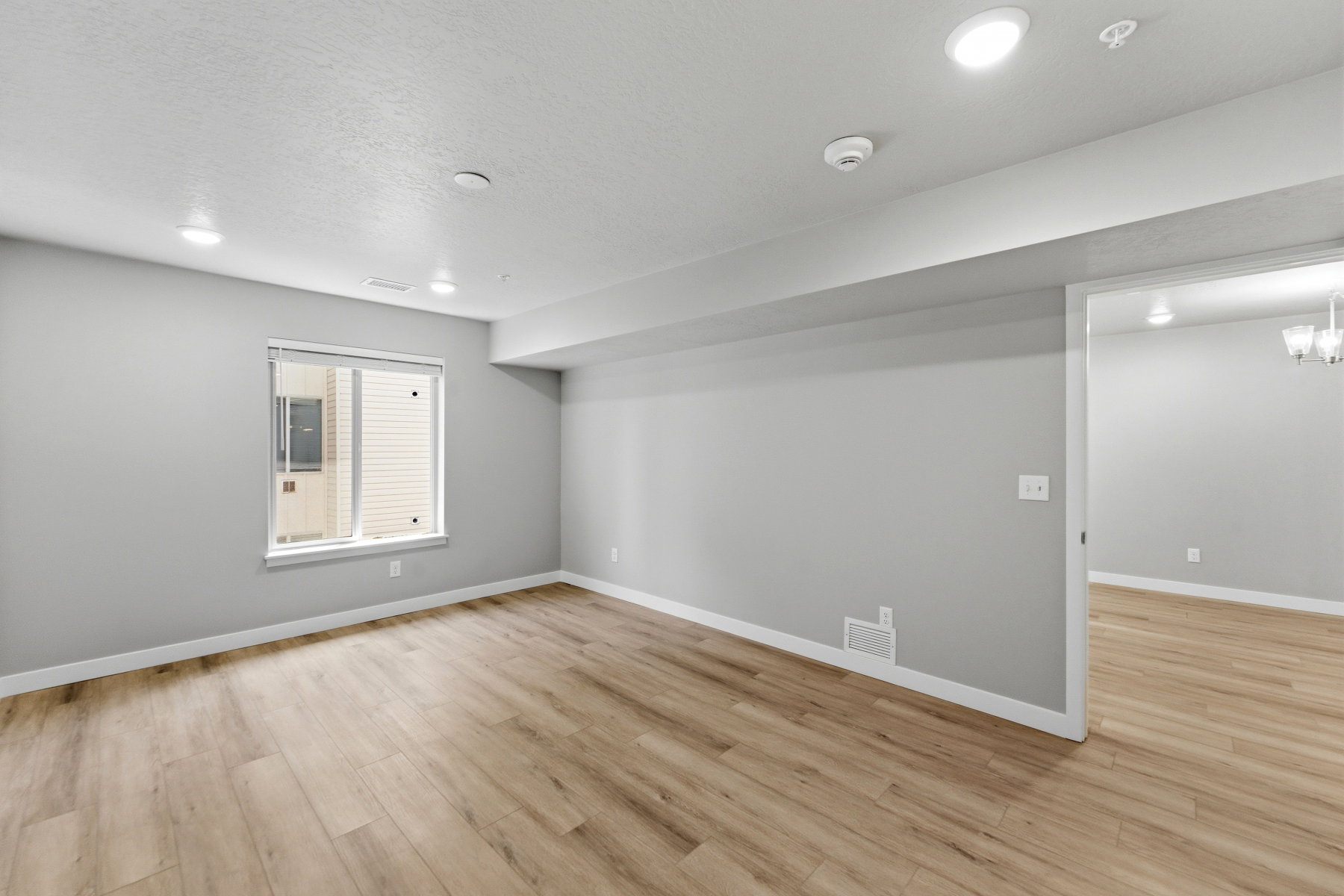 Bright room featuring wood-finish flooring, recessed lighting, and a neutral wall palette