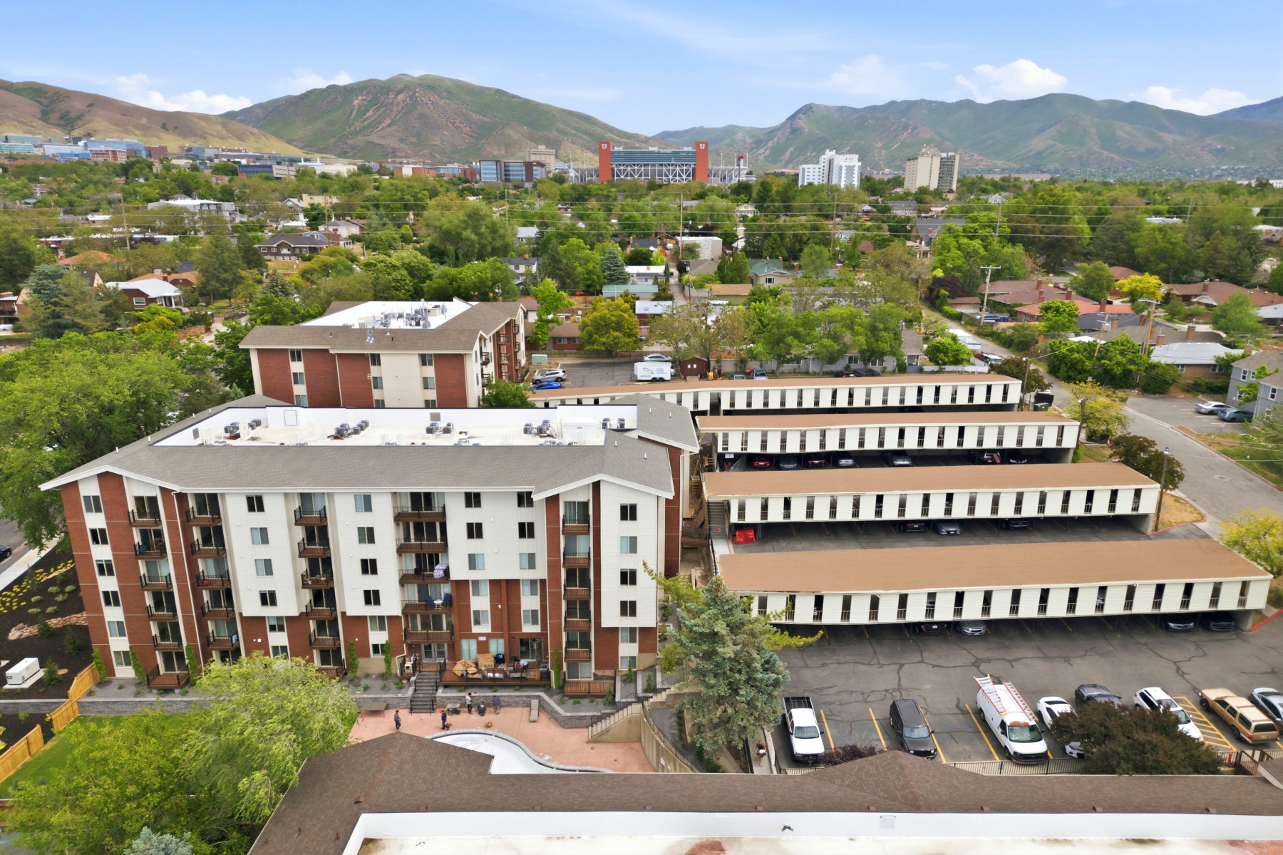 Multi-story building featuring brick and white siding with private balconies