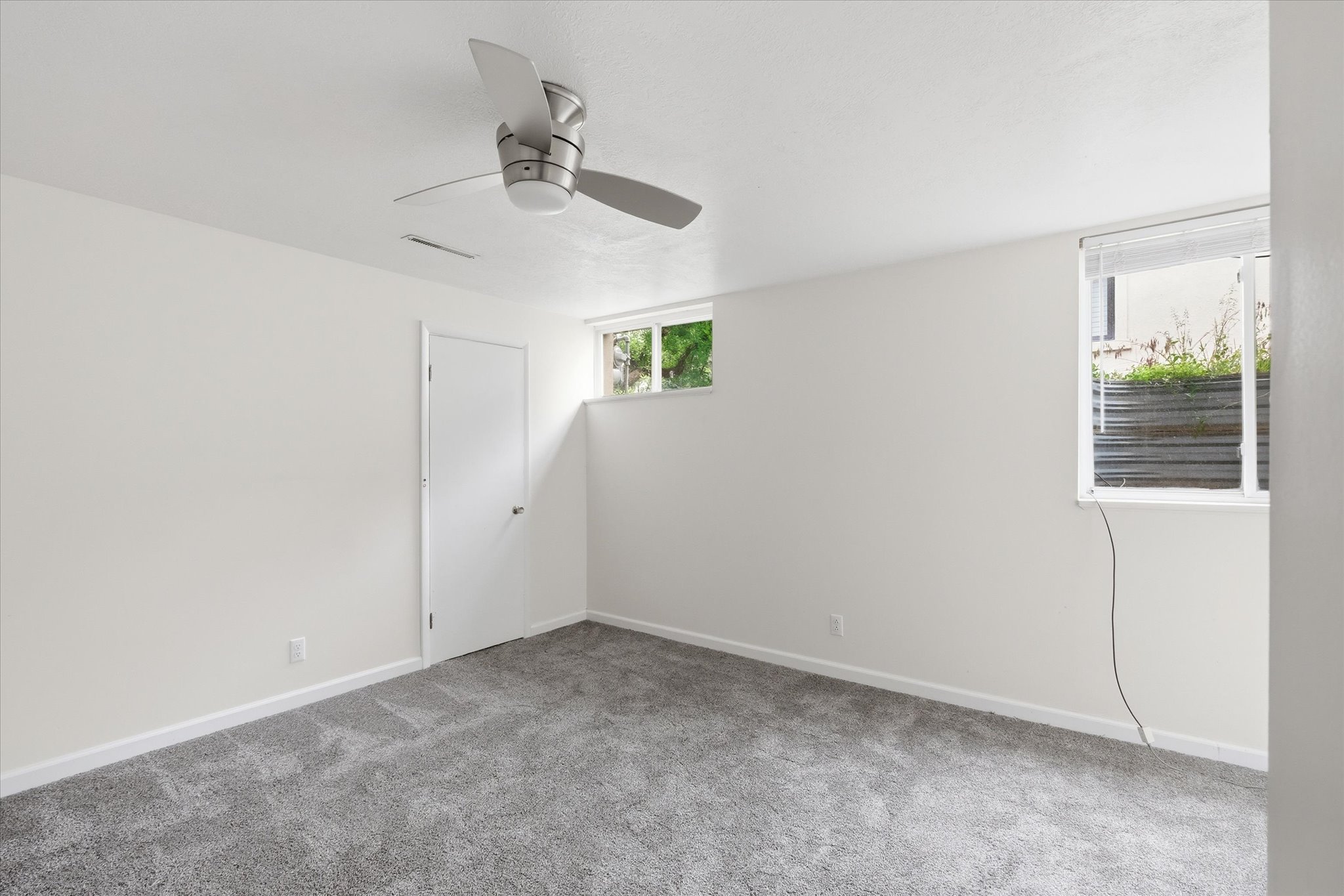 Bright room with white walls and grey carpeting