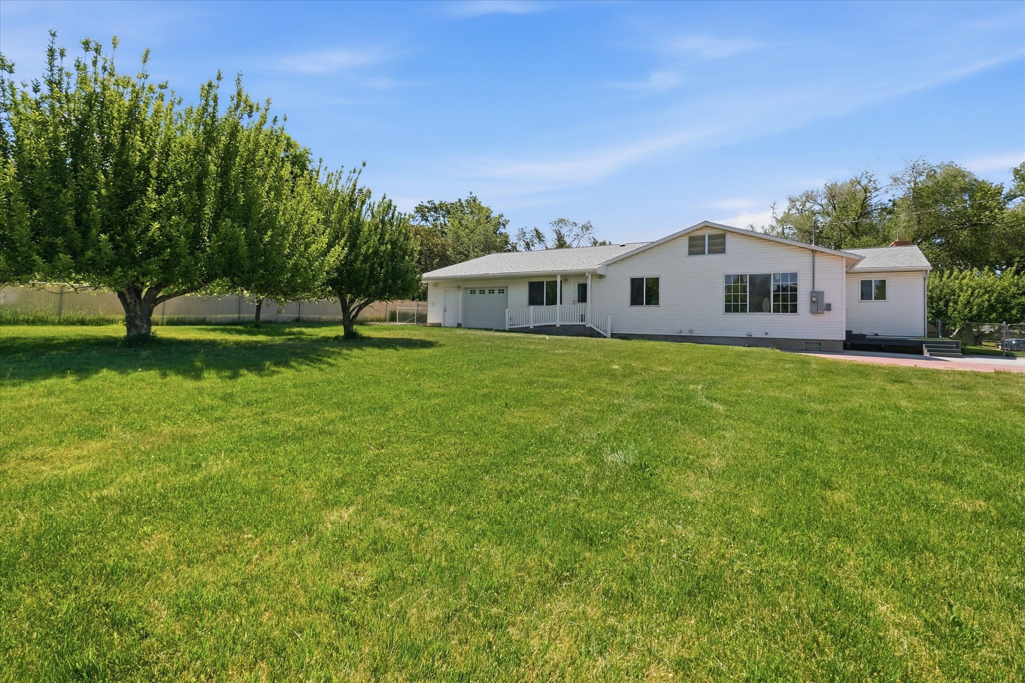Expansive green lawn featuring mature trees