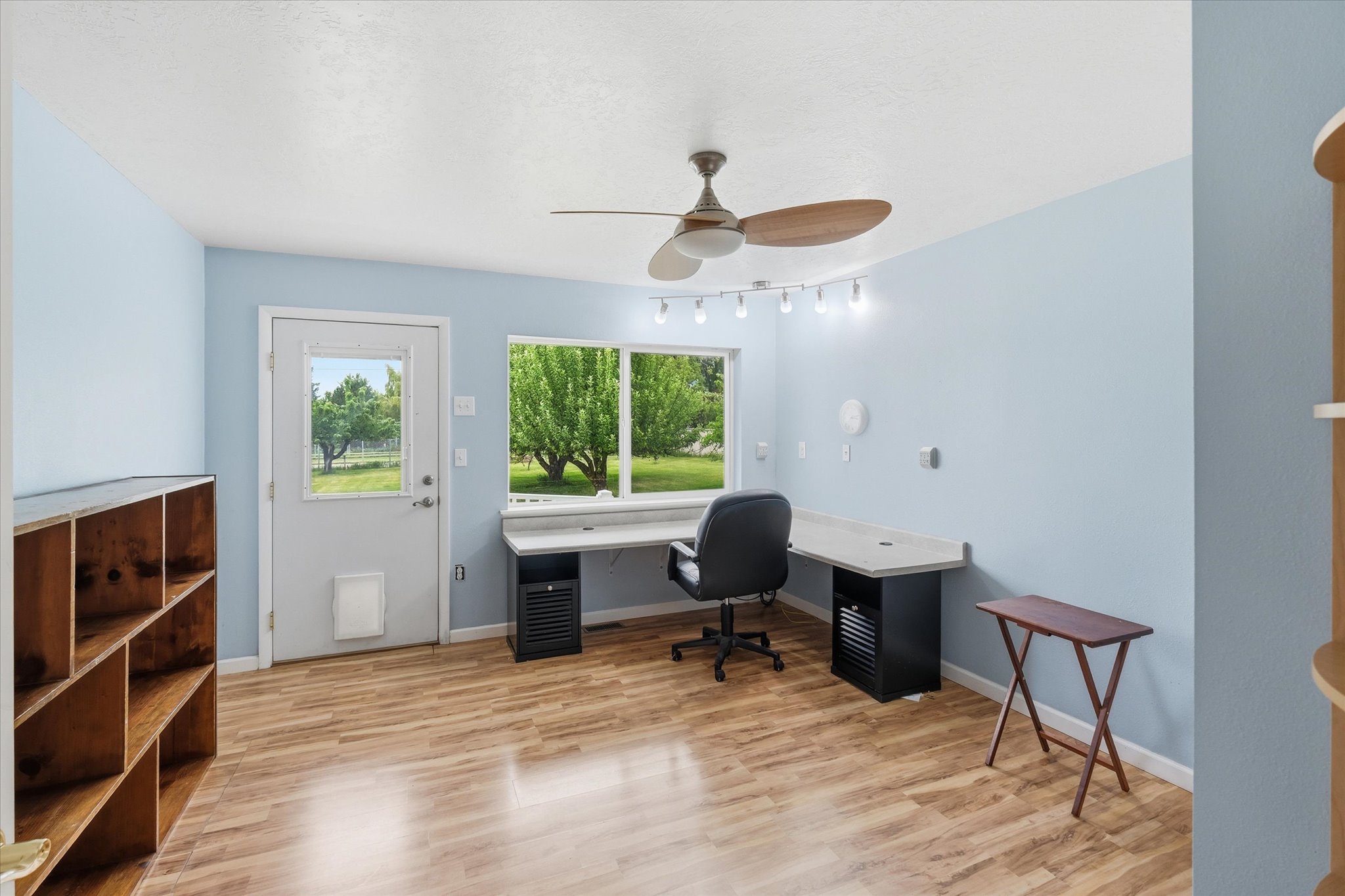 Bright interior space featuring wood-finish flooring, light blue walls, and a large window