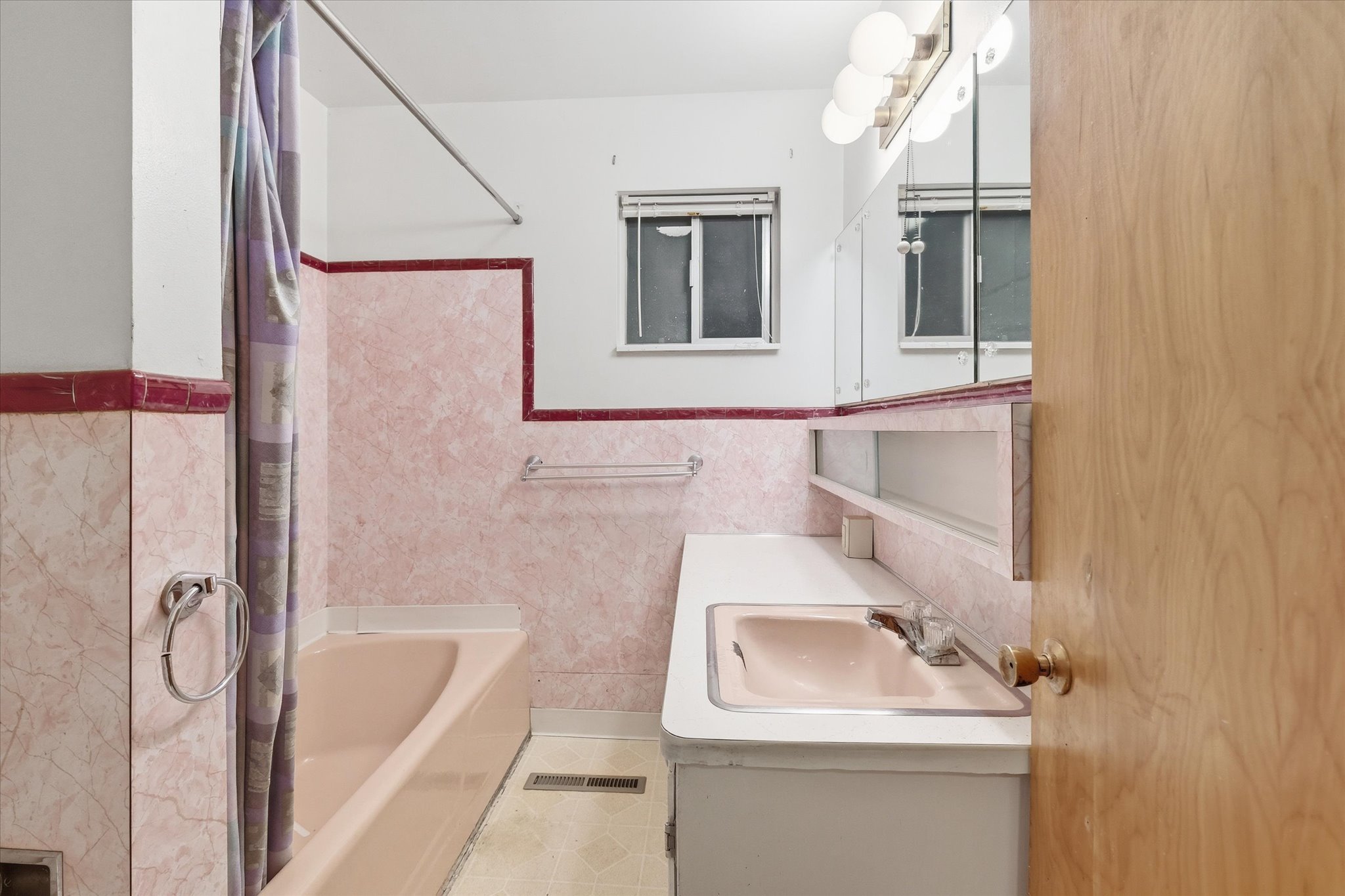 Bathroom featuring a built-in vanity with an integrated sink, a mirrored medicine cabinet, and sconce lighting