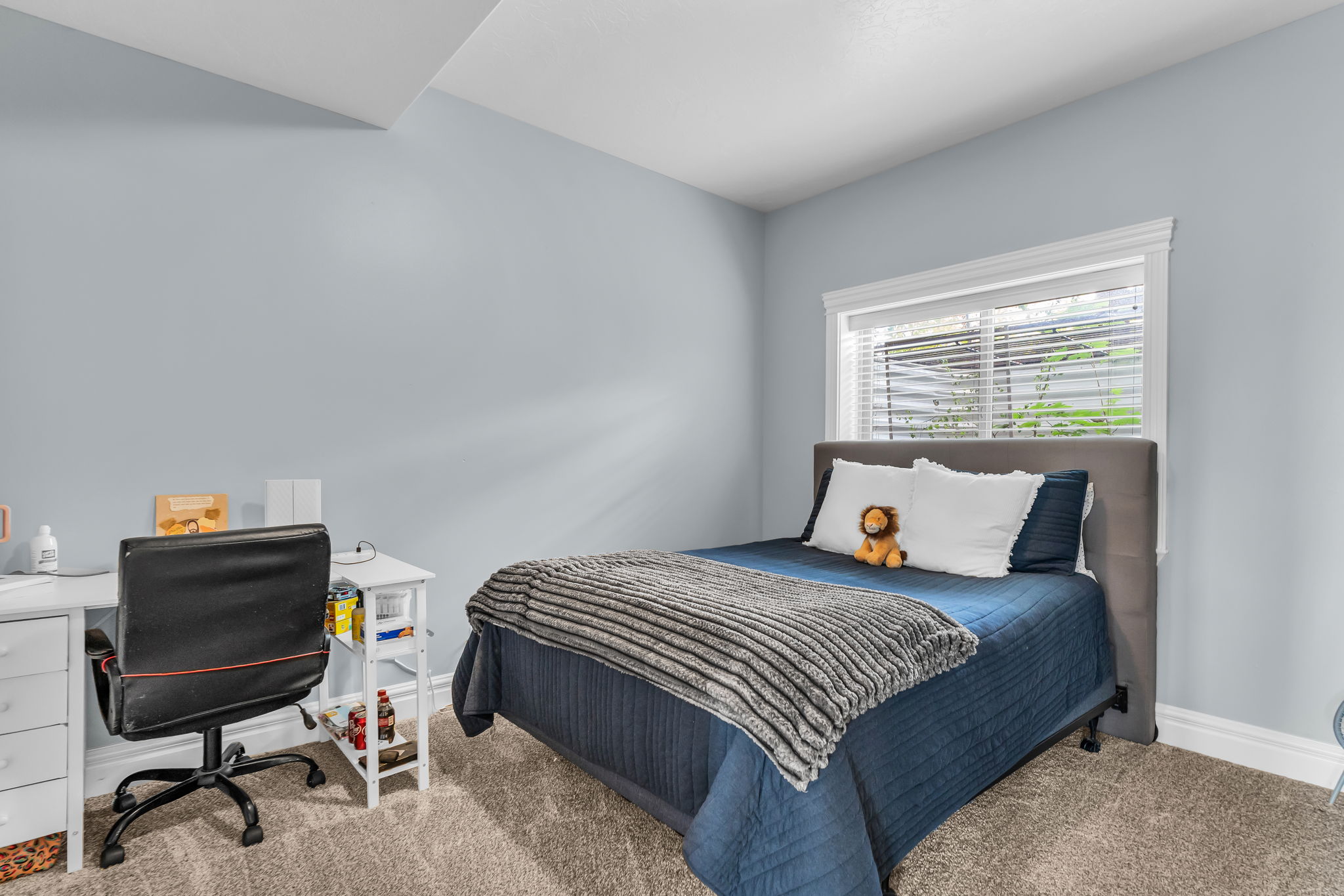 Room featuring light blue walls, white trim, and light grey carpeting