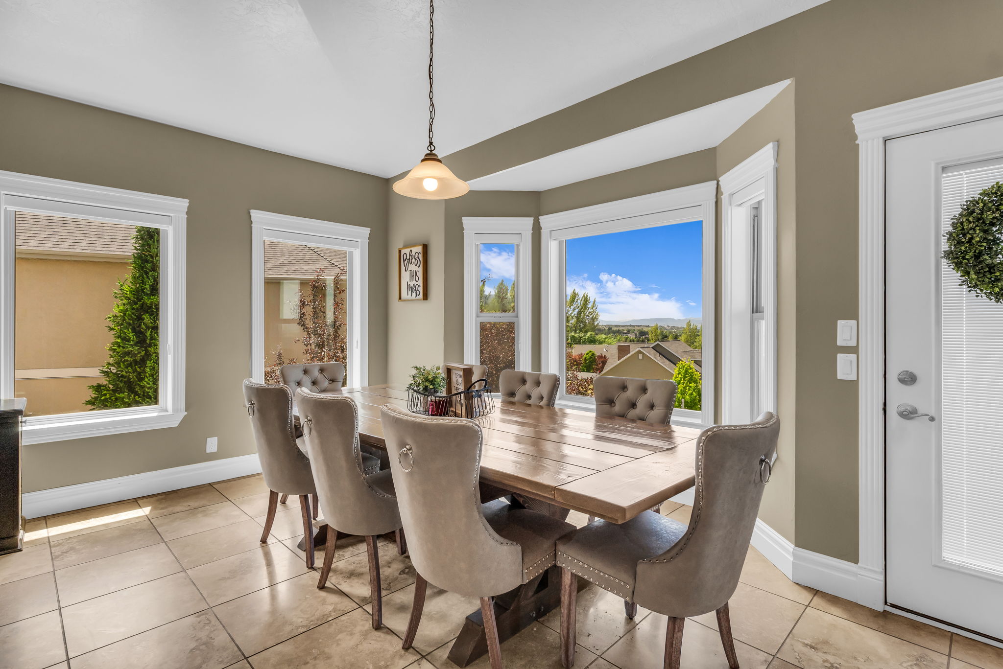 Dining area featuring a bay window with multiple panes, tile flooring, and a glass-paneled exterior door