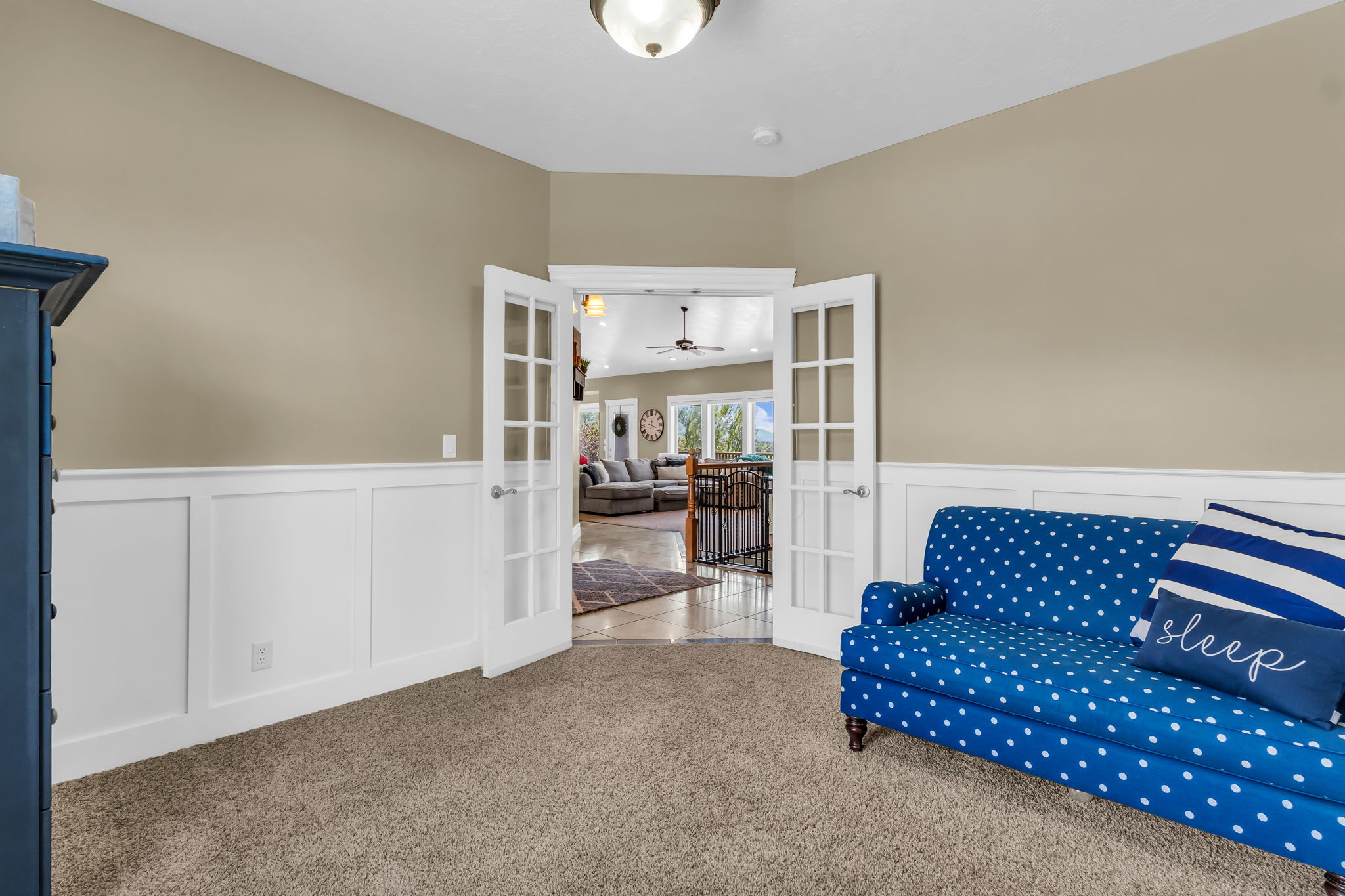 French doors with glass paneling, wainscoting, and neutral wall paint