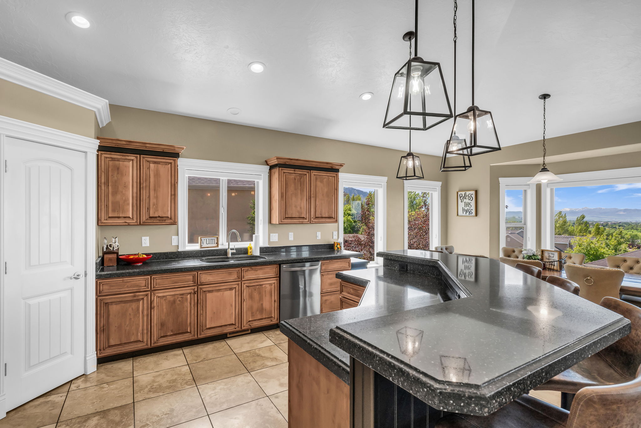 Kitchen featuring a two-tier island with a dark, speckled countertop, recessed lighting, and pendant fixtures