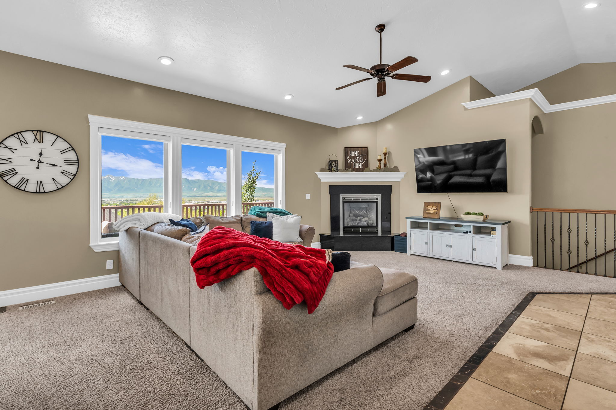 Living area featuring a fireplace with a mantel, vaulted ceilings, and recessed lighting