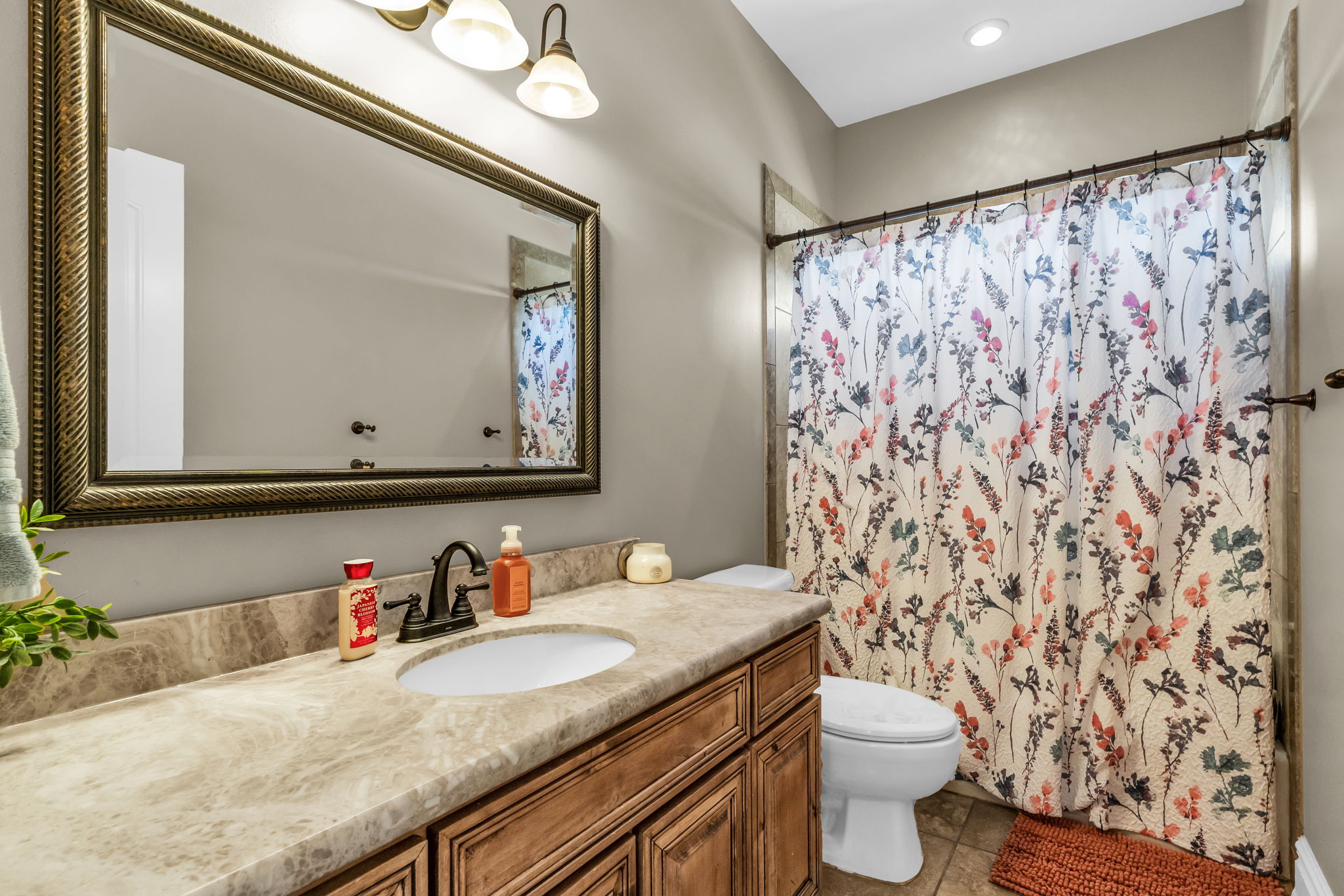 Bathroom featuring a vanity with a countertop, an undermount sink, a bronze-finish faucet, and a large framed mirror