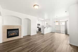 Spacious living area featuring wood-finish flooring and a tiled fireplace