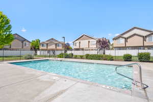 Outdoor swimming pool with concrete decking and metal handrails