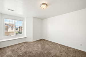 Neutral color palette throughout featuring a large window with blinds, a window seat, and plush carpet flooring