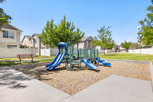 Community playground featuring a multi-level play structure with multiple slides set on wood chip surfacing