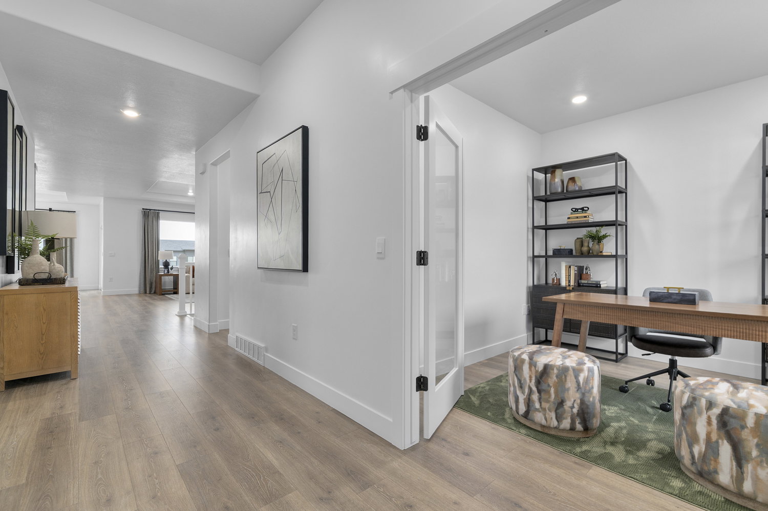 Dedicated office space with a glass-paneled door, recessed lighting, wood-finish flooring, and crisp white walls