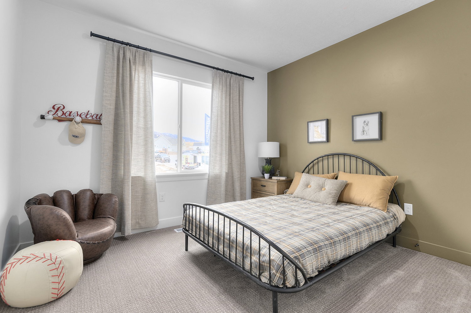 Bedroom featuring a large window, a neutral-toned accent wall, and carpet flooring