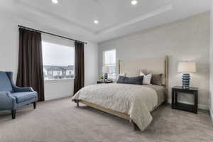 Carpeted interior room featuring a tray ceiling with recessed lighting, large windows with dark drapery, and a textured accent wall