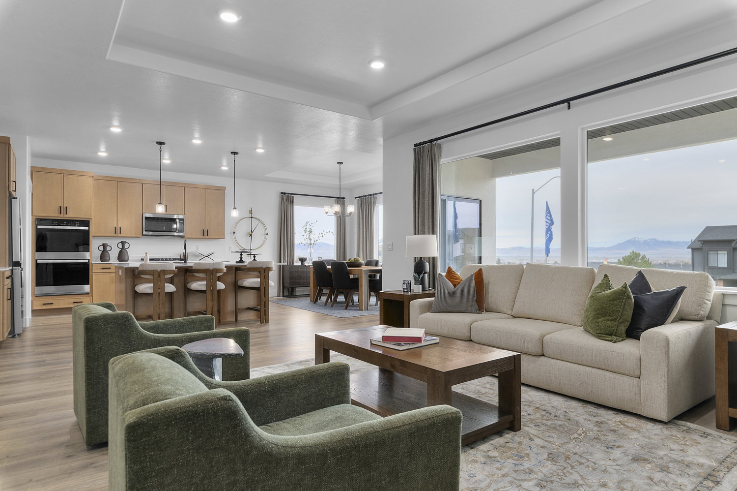Open-concept living space featuring wood-finish flooring, recessed lighting, and large windows
