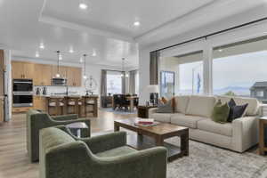 Open-concept living space featuring wood-finish flooring, recessed lighting, and large windows