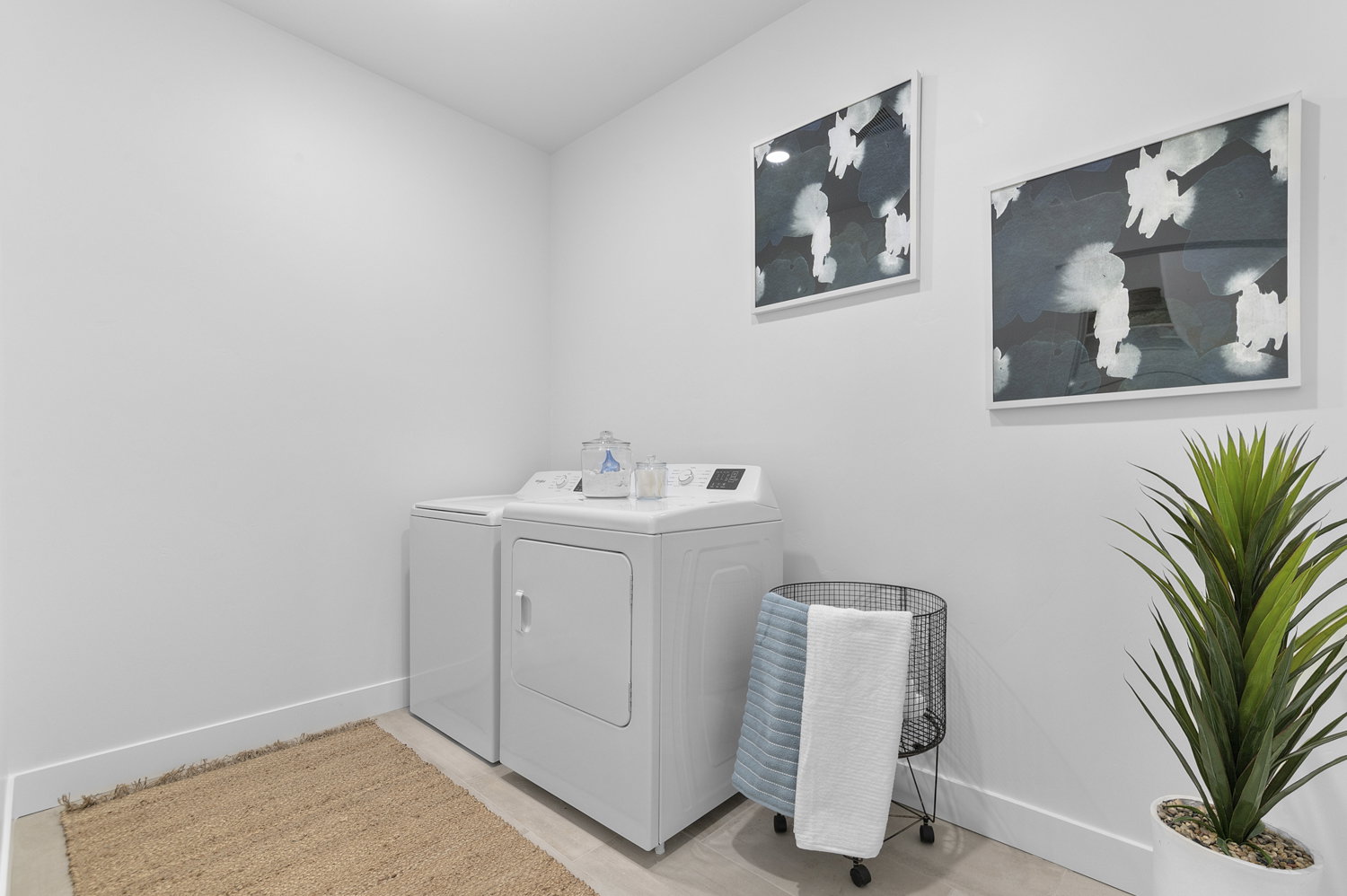 Dedicated laundry area featuring white walls, baseboards, and light-toned flooring