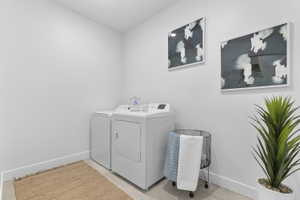 Dedicated laundry area featuring white walls, baseboards, and light-toned flooring