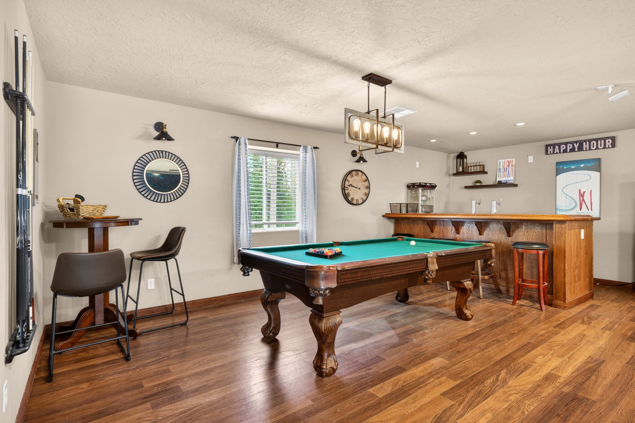 Recreation room featuring a classic billiards table, wood-finish flooring, and a built-in wet bar with a wood countertop