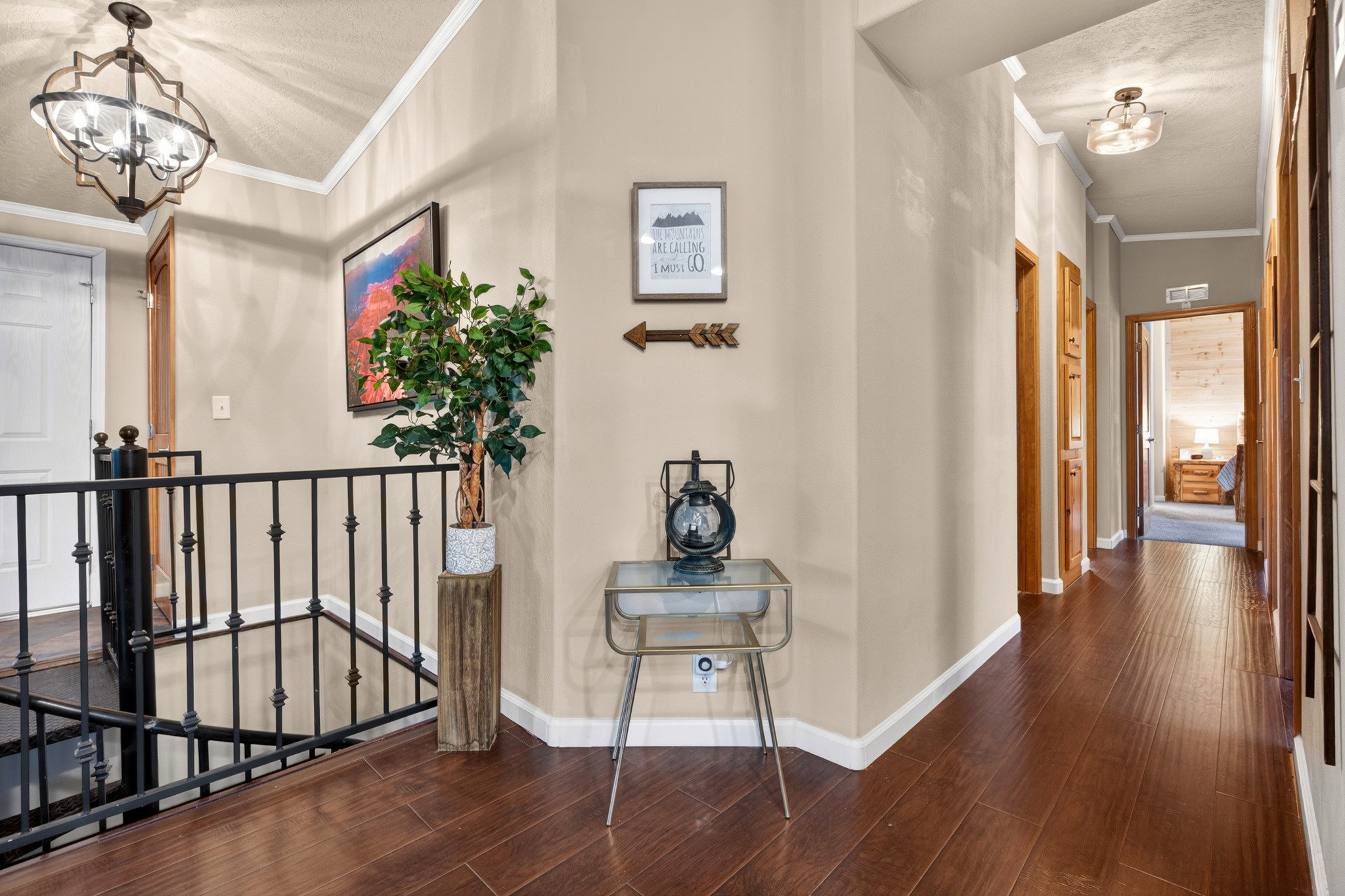 Hallway featuring wood-finish flooring, neutral wall paint, and white trim