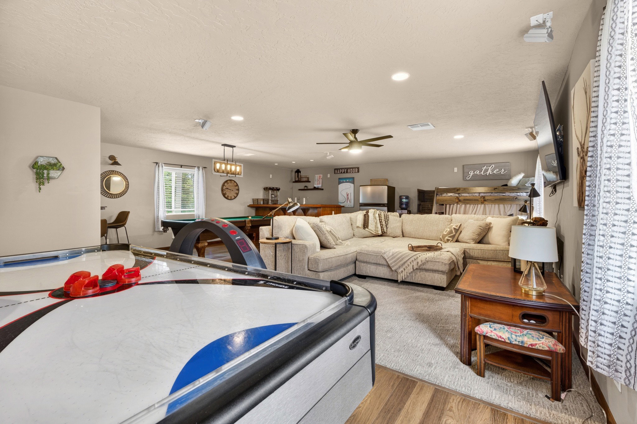 Spacious room featuring wood-finish flooring, recessed lighting, and a ceiling fan