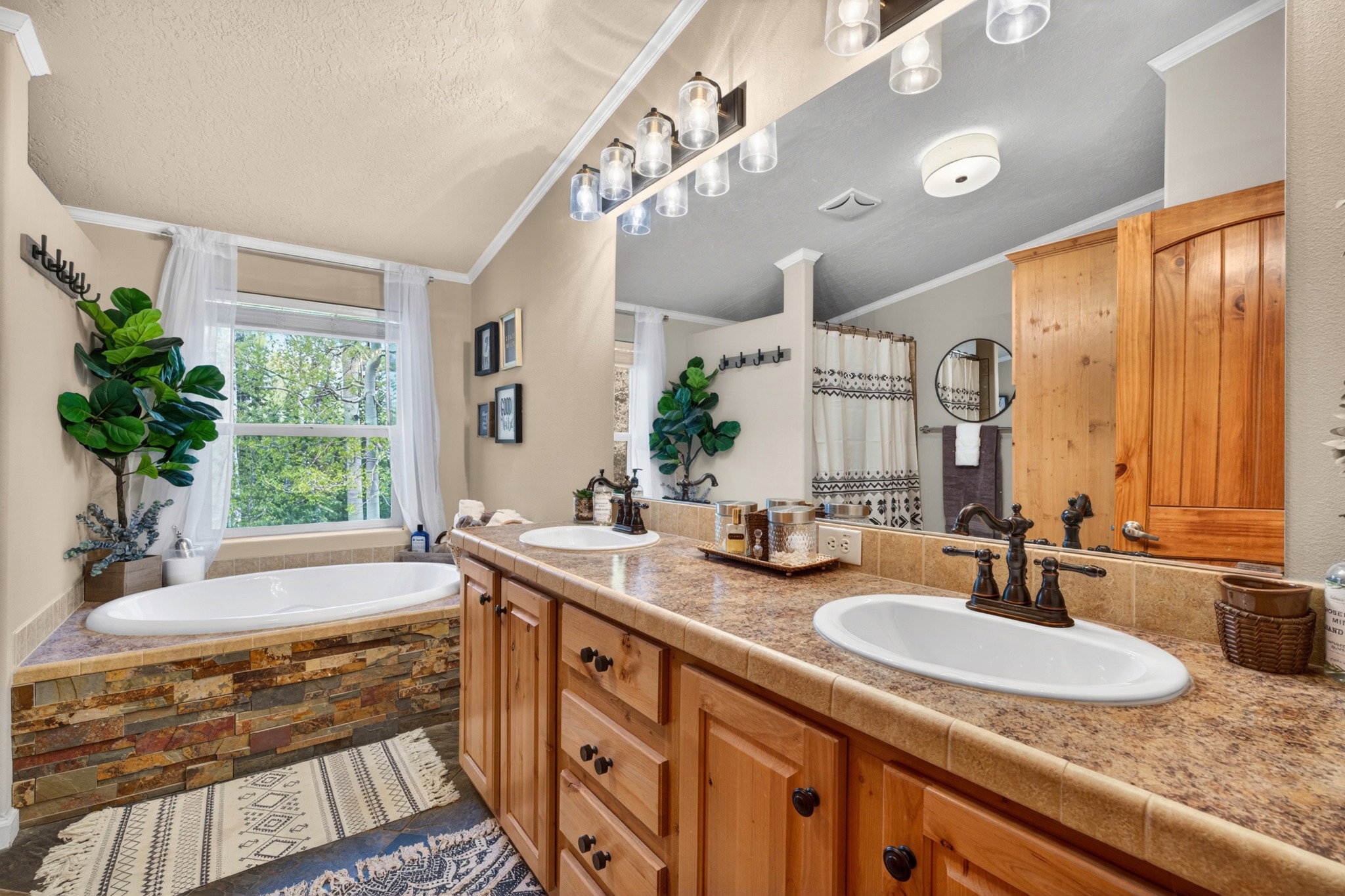 Bathroom featuring a double vanity with wood cabinetry and an oval drop-in sink