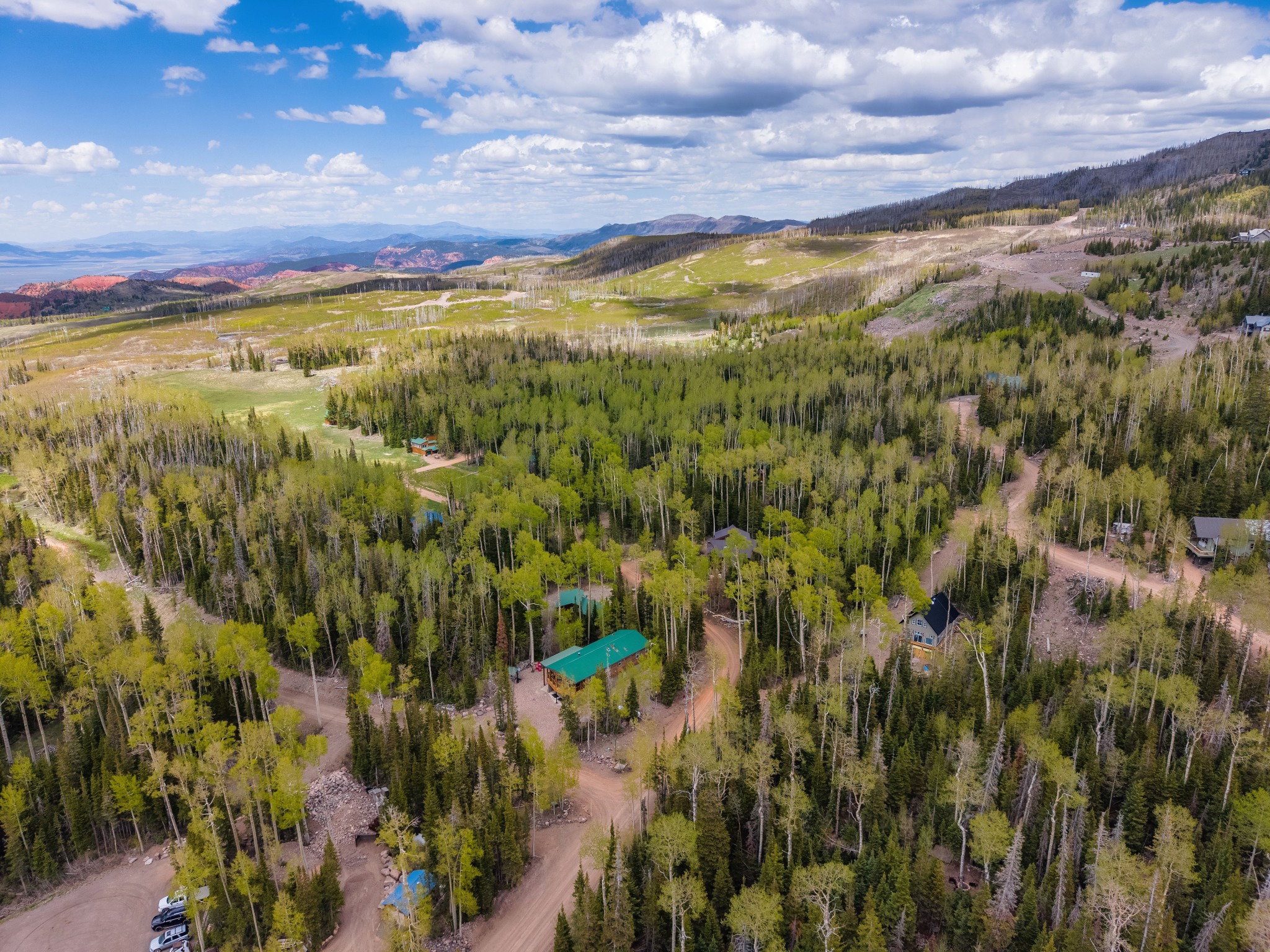 Expansive mountain landscape featuring varied tree coverage and visible structures