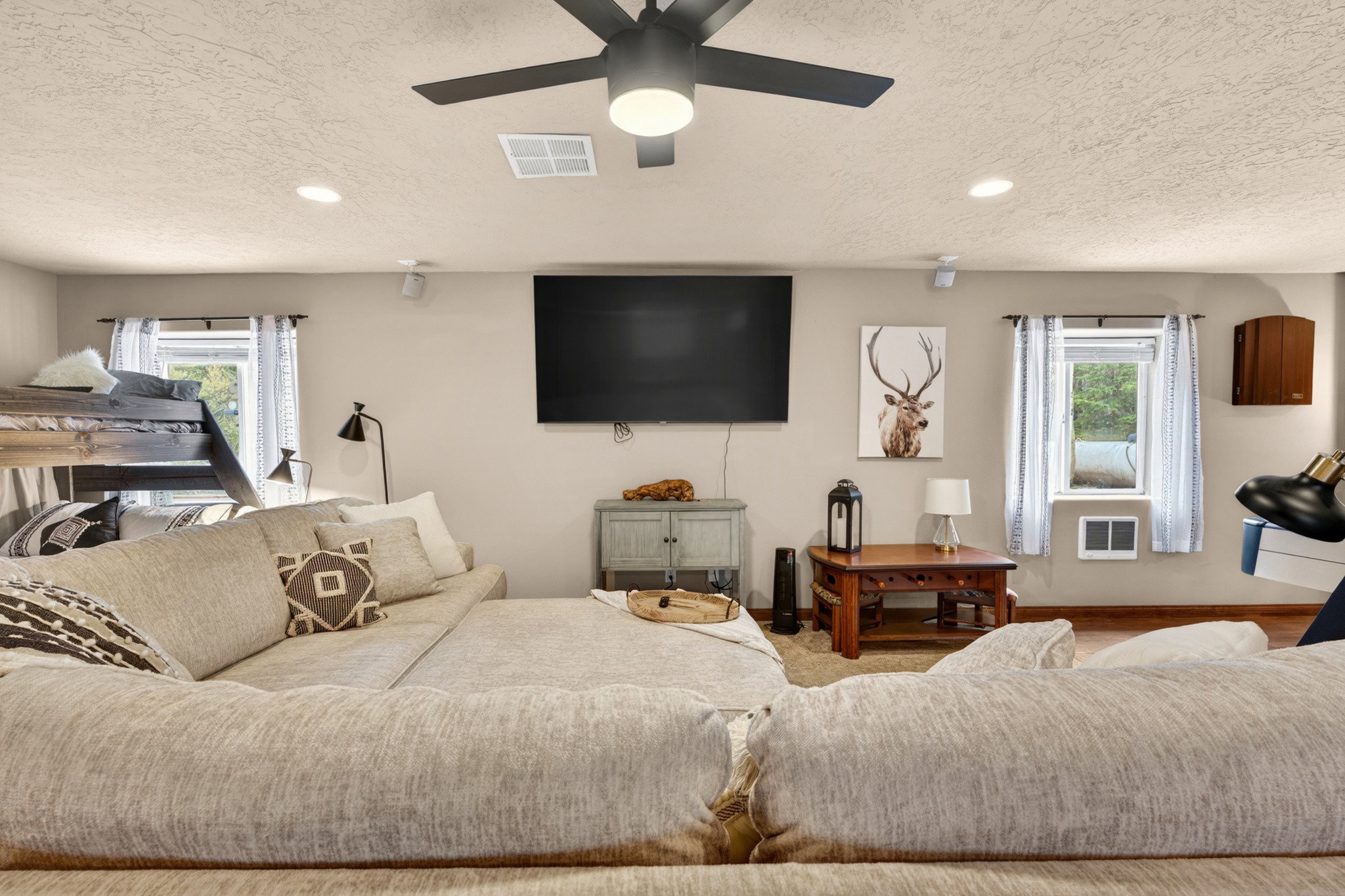 Spacious room featuring light-colored walls, recessed lighting, and a ceiling fan with integrated lighting