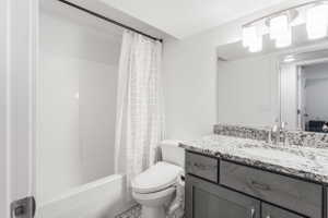 Bathroom featuring a white tub-shower combination, a vanity with a light-colored countertop, and a built-in mirror