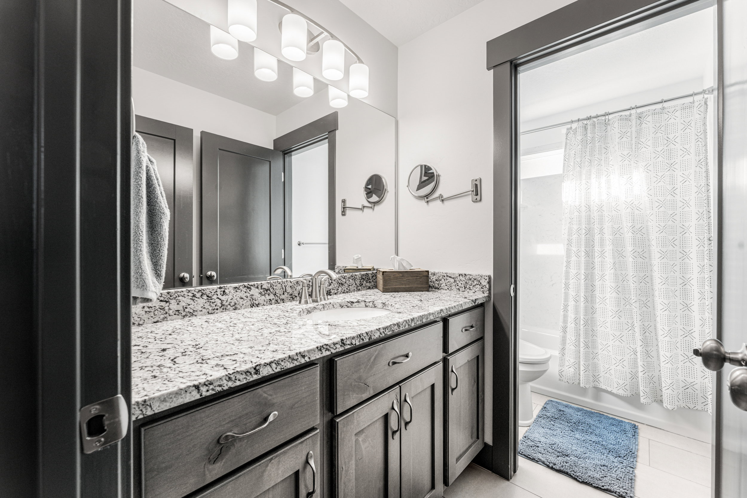 Vanity with granite countertop, integrated sink, and brushed nickel faucet