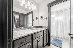 Vanity with granite countertop, integrated sink, and brushed nickel faucet