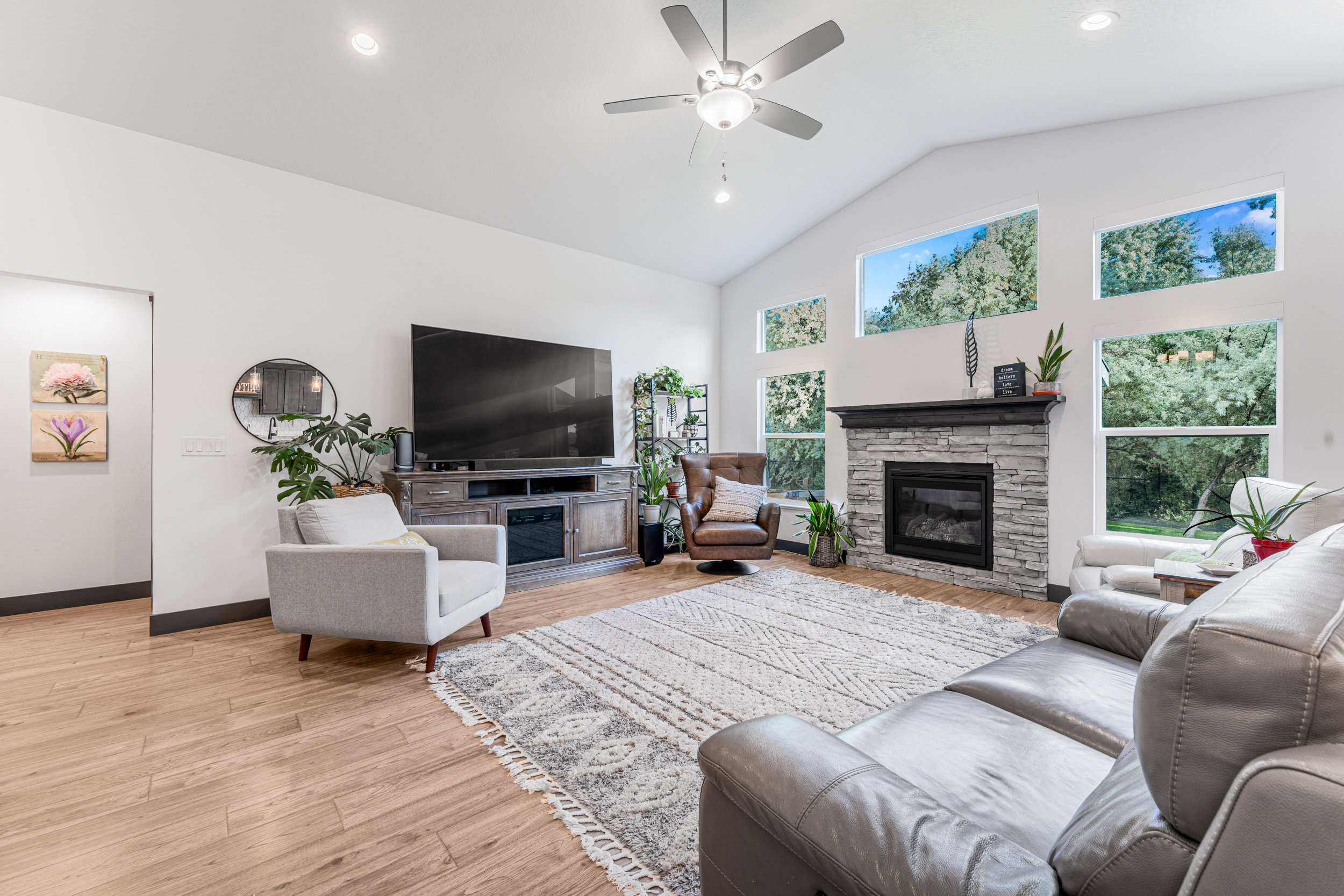 Vaulted ceilings with a ceiling fan and recessed lighting define this living space