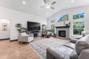 Vaulted ceilings with a ceiling fan and recessed lighting define this living space