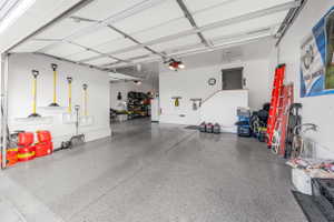 Spacious garage featuring a durable epoxy floor, white painted walls, and an overhead garage door