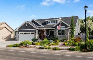 Contemporary residence featuring dark gray siding and stone accents