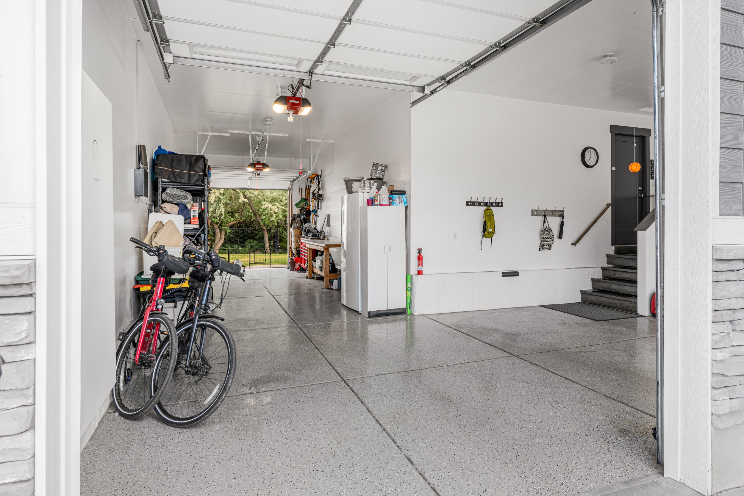 Spacious garage featuring a durable epoxy floor finish, overhead lighting, and interior access to the property